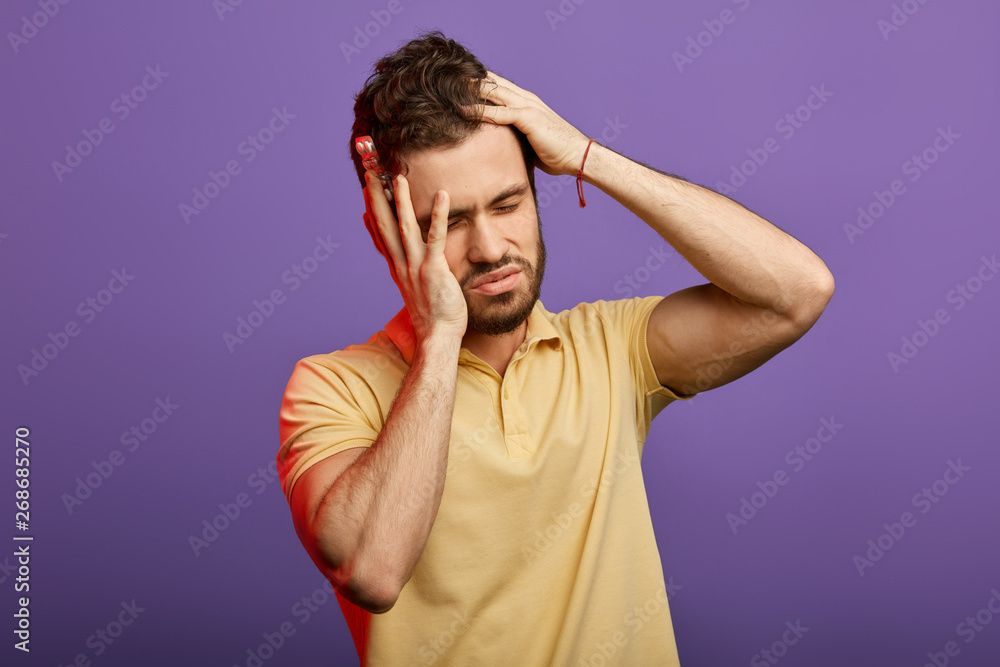 handsome unhappy man having very strong pain and holding pills, tablets. guy has high blood pressure. close up photo. studio shot.useless medicine, symptom handsome unhappy man having very strong pain and holding pills, tablets. guy has high blood pressure. close up photo. studio shot.useless medicine, symptom