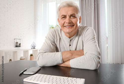 Mature man using video chat at home, view from web camera