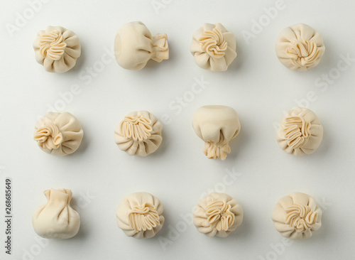 Composition with raw dumplings on white background, top view