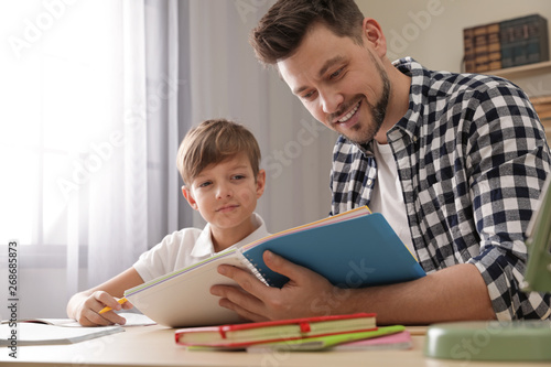 Dad helping his son with school assignment at home