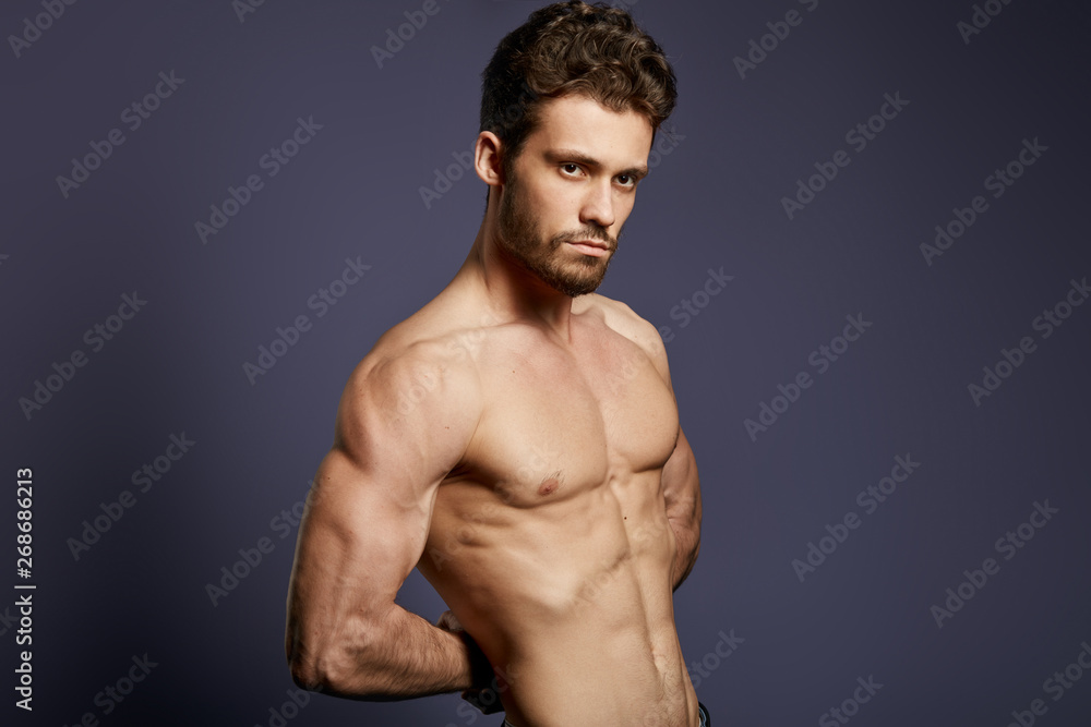 attractive serious man hiding his arms behind the back and posing to the camera,sportsman demonstrates his strong arms . isolated black background attractive serious man hiding his arms behind the back and posing to the camera,sportsman demonstrates his strong arms . isolated black background