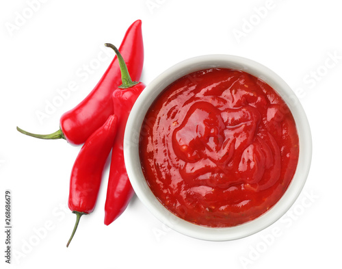 Bowl with red sauce and fresh chili peppers isolated on white, top view