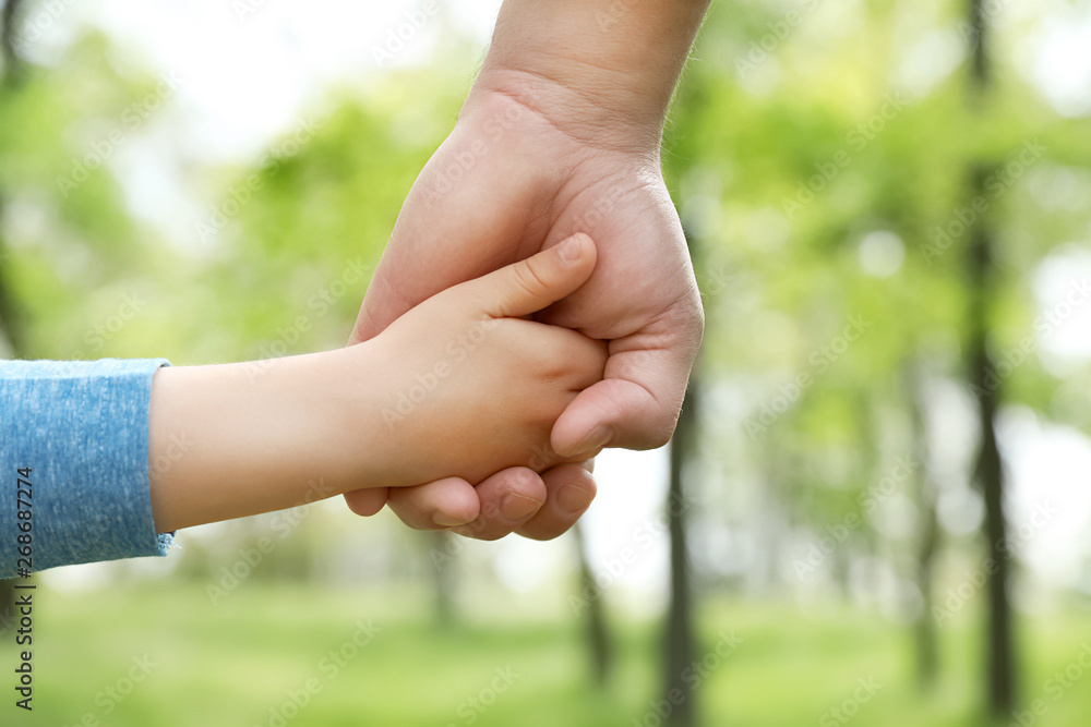 Little child holding hands with his father outdoors, closeup. Family time Little child holding hands with his father outdoors, closeup. Family time