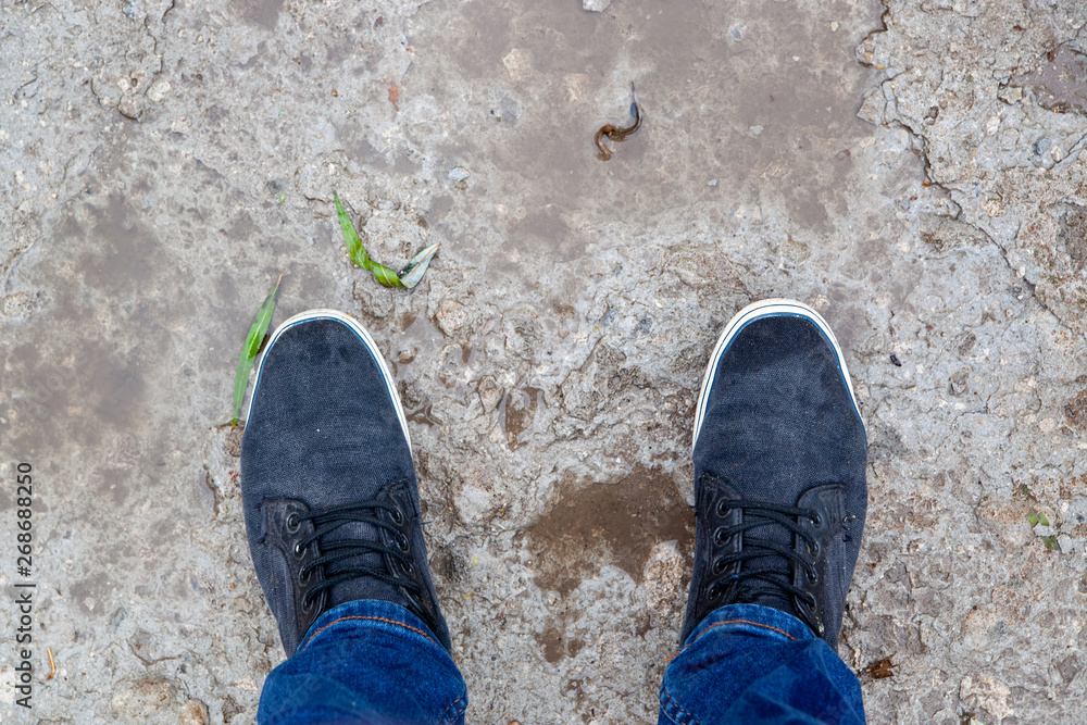 sports shoes in clothing style, sneakers with jeans on a puddle sports shoes in clothing style, sneakers with jeans on a puddle