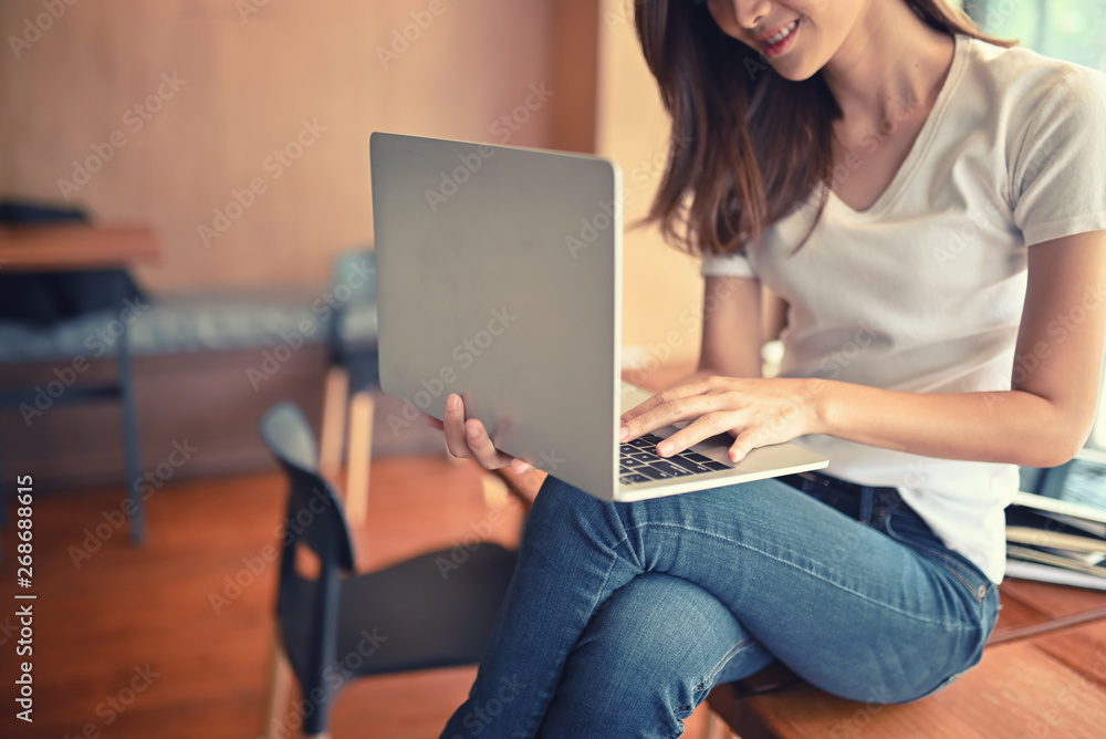 30S Hipster Female using laptop and sitting on wooden table. 30S Hipster Female using laptop and sitting on wooden table.