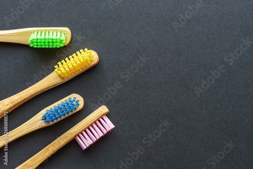 bamboo toothbrushes in different colours on dark rough background. plastic-free concept