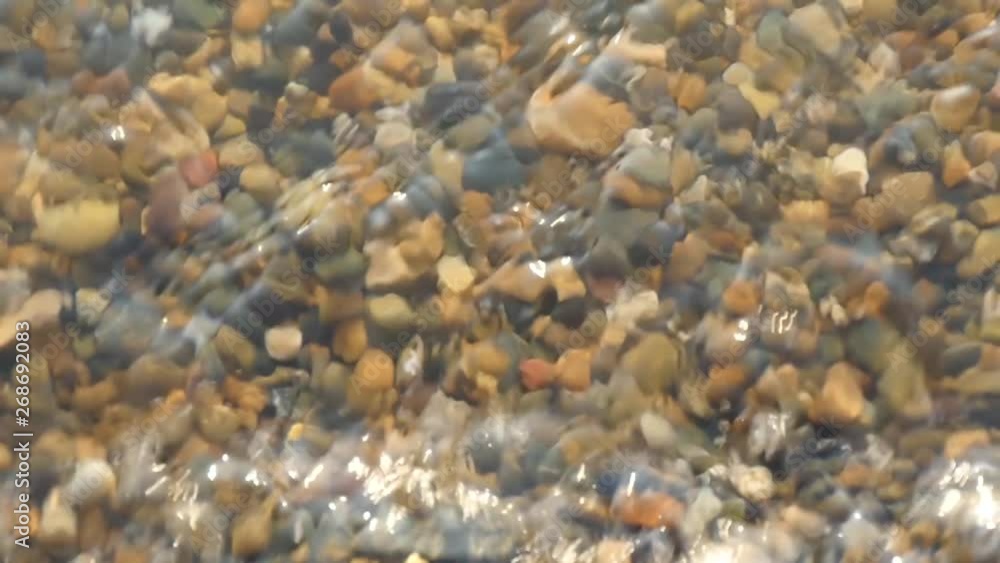 Pebbles on the sea coast, washed by water in slow motion, close-up Pebbles on the sea coast, washed by water in slow motion, close-up
