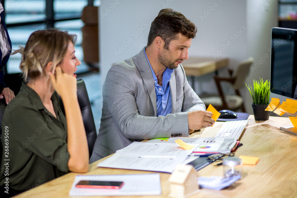Fototapeta premium Group of happy business people men and woman working together with paper document file in meeting room.teamwork of two girl and one caucasian man discussing in office