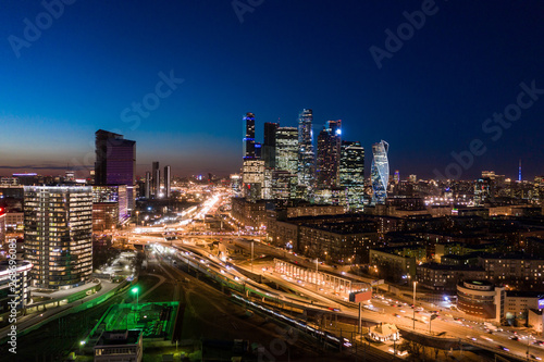 high-rise buildings and transport metropolis  traffic and blurry lights of cars on multi-lane highways and road junction at night in Moscow.