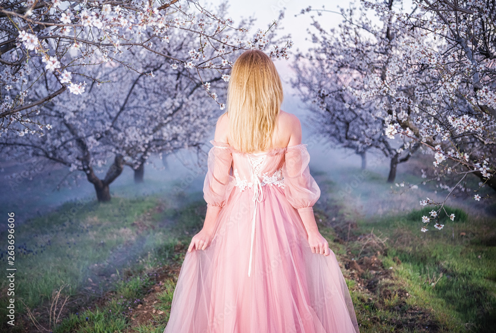 Sevastopol, Republic of Crimea - April 1, 2019: A girl in a beautiful pink dress among flowering almond branches Sevastopol, Republic of Crimea - April 1, 2019: A girl in a beautiful pink dress among flowering almond branches