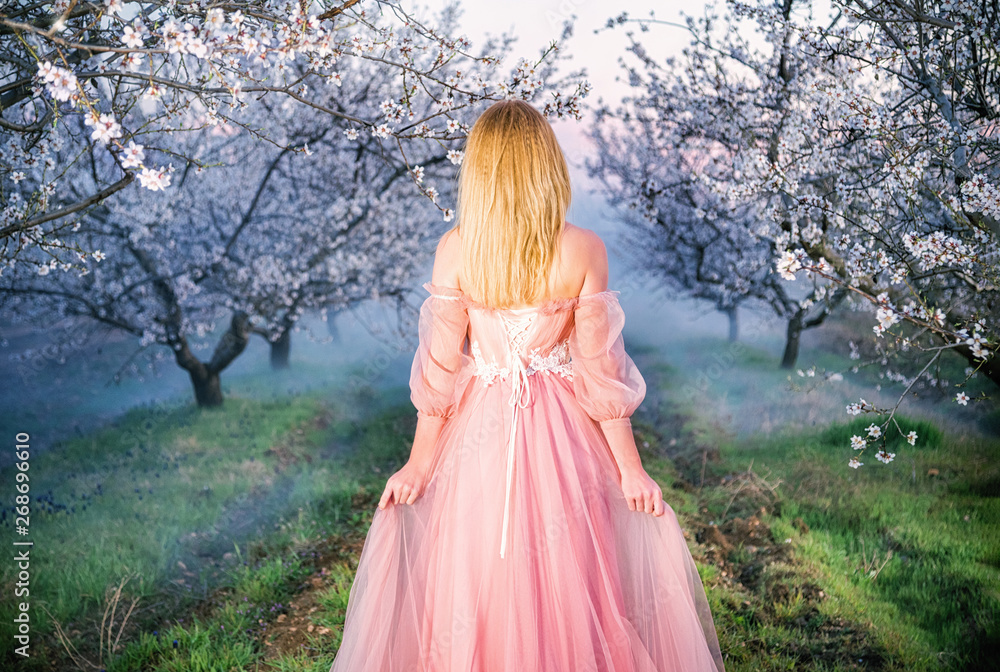 Sevastopol, Republic of Crimea - April 1, 2019: A girl in a beautiful pink dress among flowering almond branches Sevastopol, Republic of Crimea - April 1, 2019: A girl in a beautiful pink dress among flowering almond branches