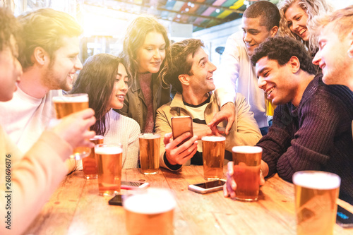 Canvas Print Happy millennial friends at pub drinking beer