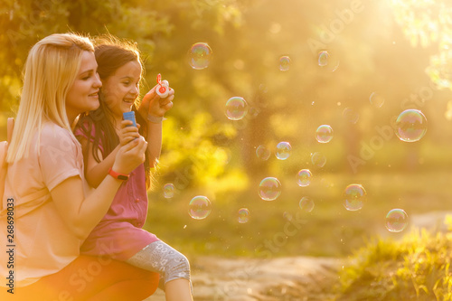 Mother and daughter family time  blowing bubbles