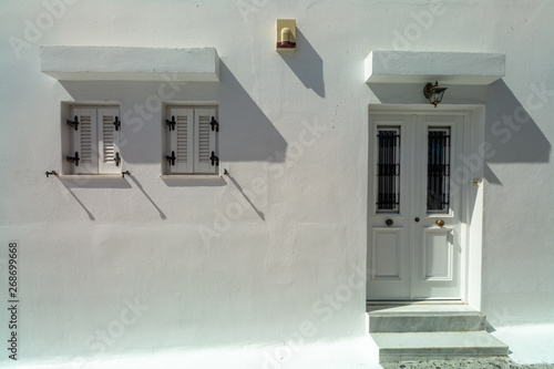 antique white locked door and two window colonial style on white wall