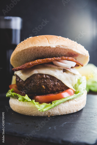 Delicious burgers with beef patty, bacon, cheese and cabbage