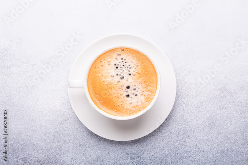 Cup of coffee on stone background. Office workplace. Top view