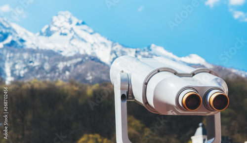 touristic telescope look at the city with view snow mountains, closeup binocular on background viewpoint observe vision, metal coin operated in panorama observation, travel nature concept