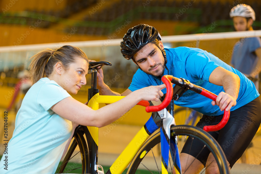 Naklejka premium female bicycle technician mending the cyclist bike