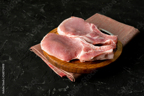 top view of raw meat uncooked slices, cut pork on a wooden board isolateds