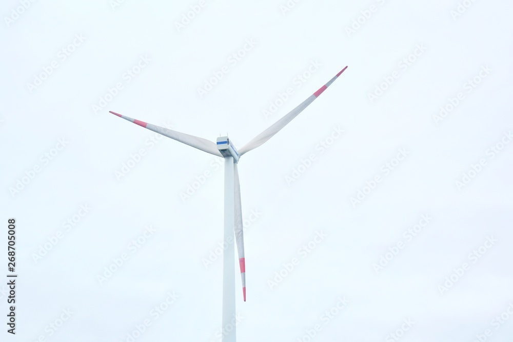 Wind turbine on background of blue sky. Alternative renewable clean energy. Wind mill turbines generating electricity. Electricity wind station for alternative renewable ecological energy