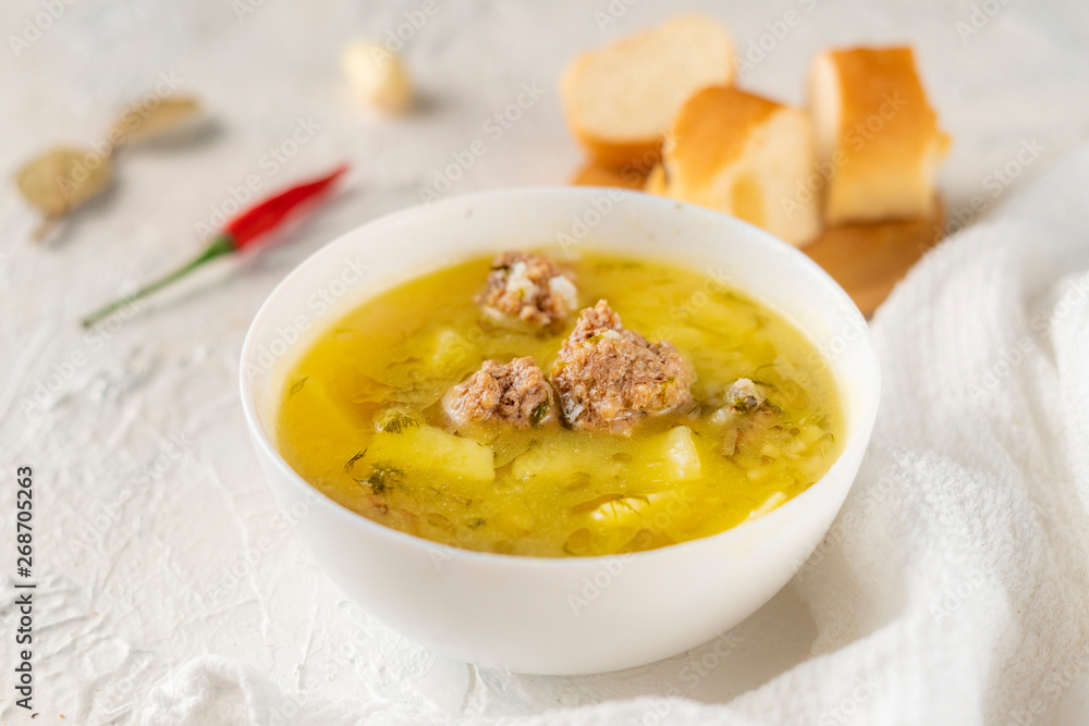 hot fresh boiled soup with meatballs and potato with bread on a white table, tasty dinners hot fresh boiled soup with meatballs and potato with bread on a white table, tasty dinners