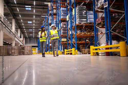 Photography Warehouse managers walking in a large storage department controlling distribution to the market