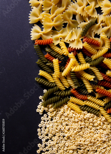 Different kinds of spaghetti on the black background. Macaroni isolated on the black background. Cuisine concept. 