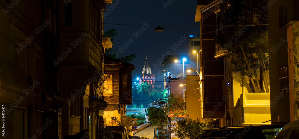 Naklejka Fantastic view of the Galata Tower from the historical site of the city with old buildings, street lights and trees. Istanbul, Turkey.