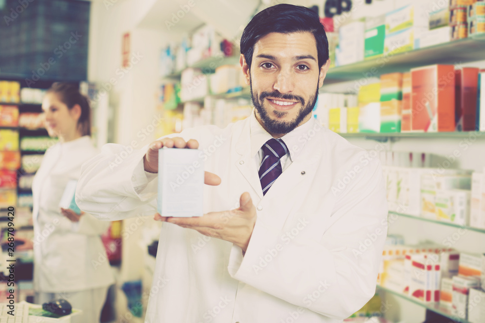 Pharmacist holding medicines in drugstore