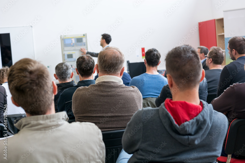 Fototapeta premium Audience at business presentation listening to person giving a speach.