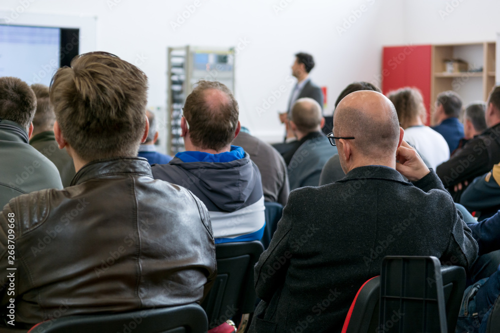 Fototapeta premium Audience at business presentation listening to person giving a speach.