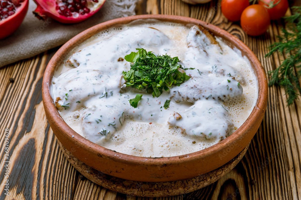 chicken chkmeruli in Georgian on wooden background chicken chkmeruli in Georgian on wooden background