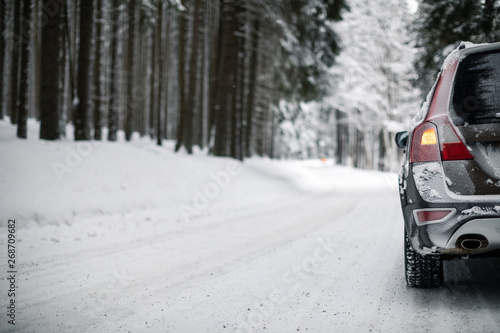 Car on a snowy winter road amid forests - using its four wheel drive capacities to get through the snow © lightpoet