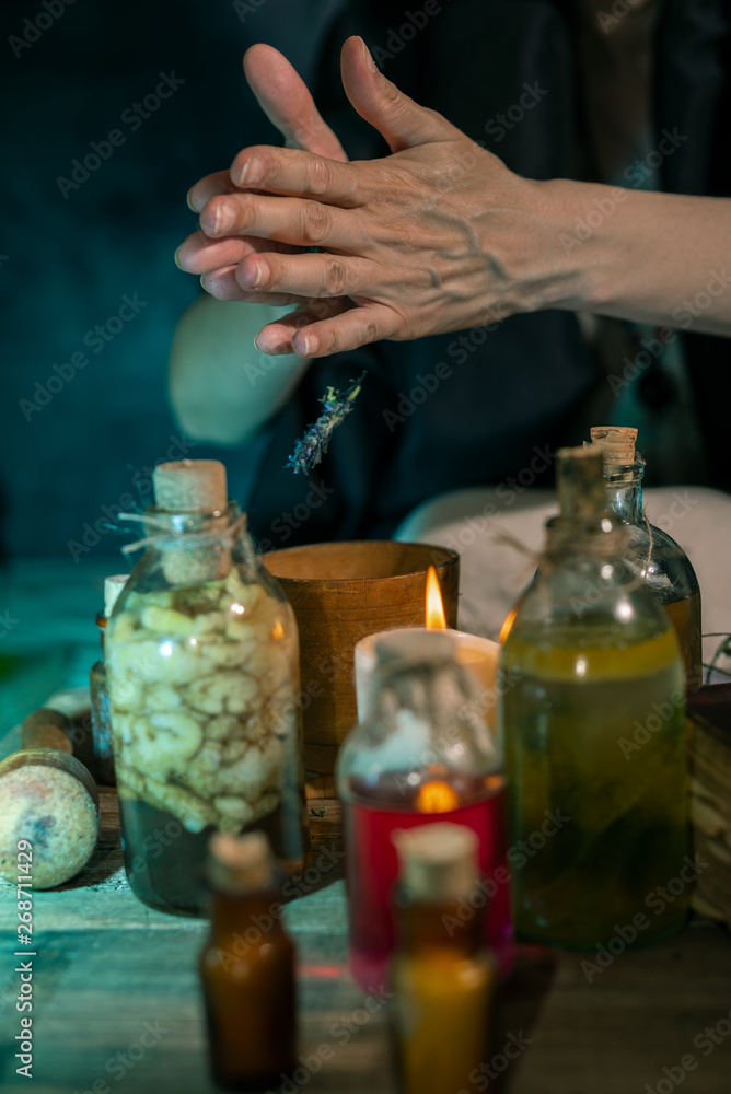 Dark Witch at work: black magic woman makes the witchery by mixing herbs, casting the spells, running magic rituals Dark Witch at work: black magic woman makes the witchery by mixing herbs, casting the spells, running magic rituals