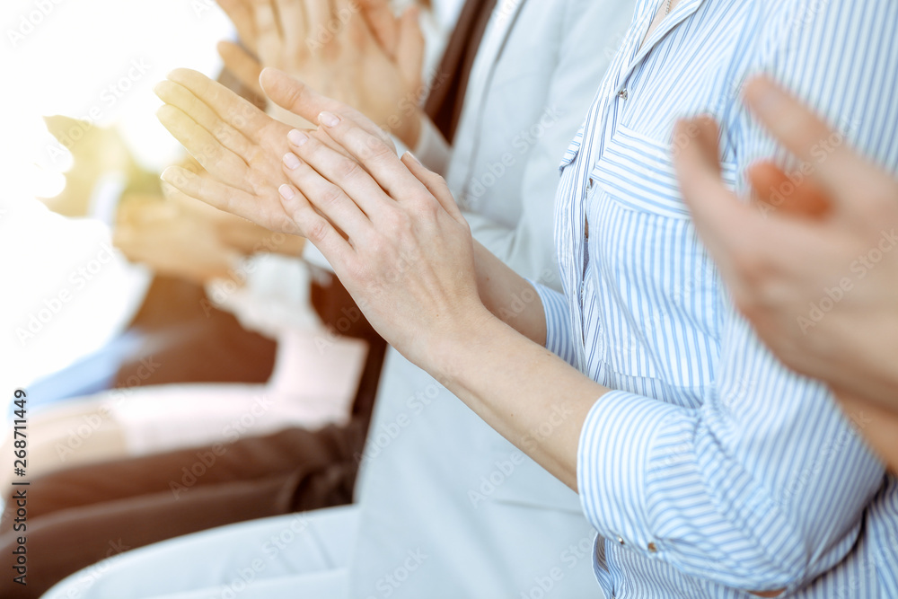 Business people clapping and applause at meeting or conference, close-up of hands. Group of unknown businessmen and women in modern white office. Success teamwork or corporate coaching concept