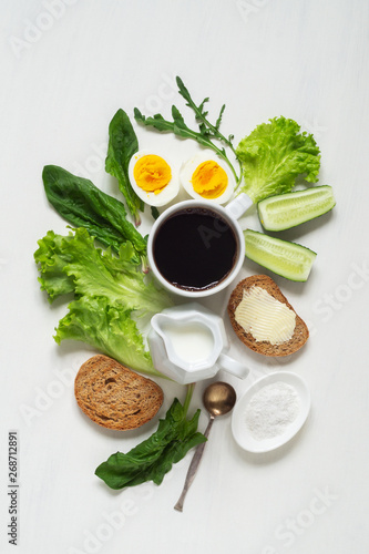 Healthy breakfast. Cup of coffee, eggs, toast with butter and leaves of spinach