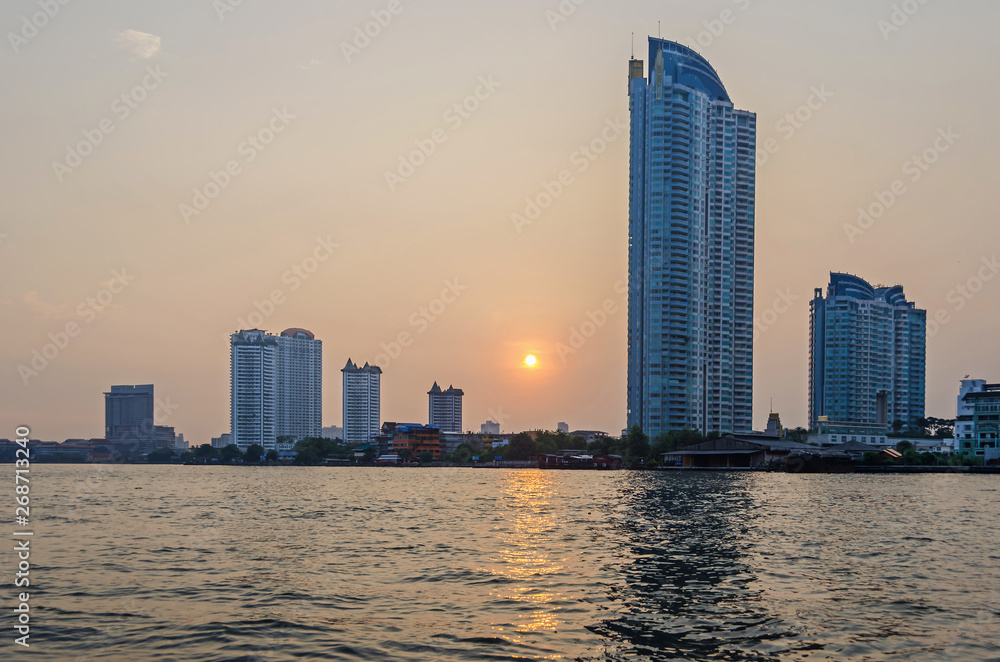 Skyline of Bangkok  at the banks of the Chao Phraya River at sunset