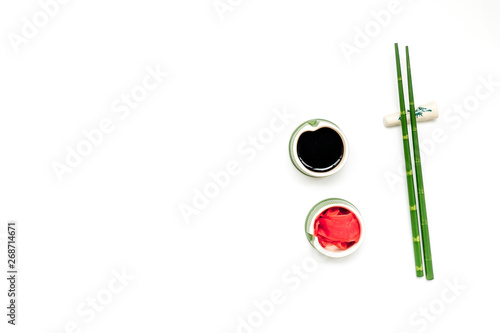 asian cuisine set with bamboo sticks, soy sauce and ginger for sushi and maki on white background top view mock up © 9dreamstudio