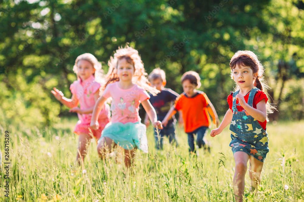 Large group of kids, friends boys and girls running in the park on sunny summer day in casual clothes . Large group of kids, friends boys and girls running in the park on sunny summer day in casual clothes .