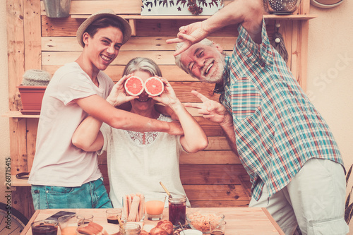 Tablou pe pânză Happy senior couple with teenager nephew have fun at breakfast