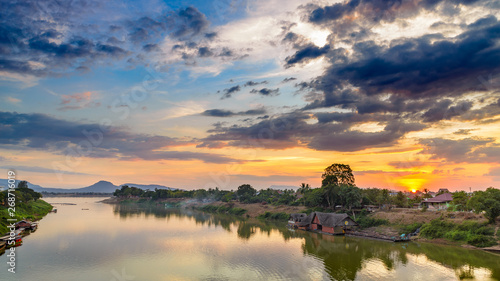 Mekong River Pakse Laos sunset dramatic sky reflection on water village on riverbank travel destination in South East Asia photo