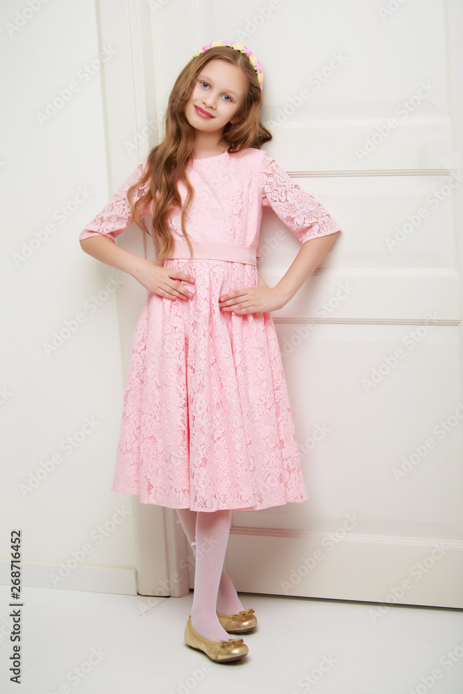 A little girl is standing by the door. A little girl is standing by the door.