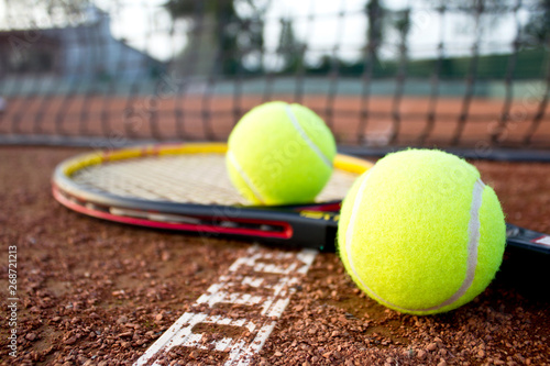 Tennis racket and balls on the clay tennis court. Close up.  © Betl
