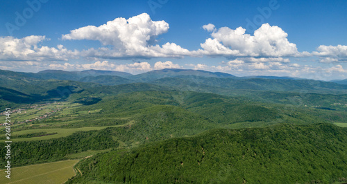 Mountains covered with green forest and river. Carpathians. View from above. Picture taken with a drone.