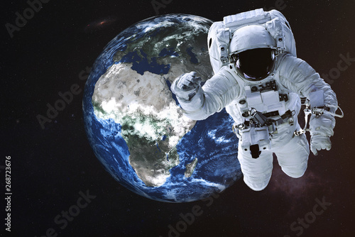 Astronaut near the Earth planet of Solar system. Science fiction. Elements of the image are furnished by NASA