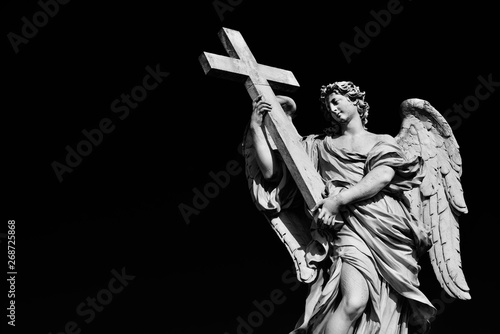 Angel statue holding Holy Cross. A 17th century baroque masterpiece at the top of Sant'Angelo Bridge in the center of Rome (Black and White with copy space) photo