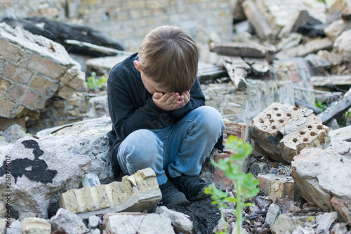 Tableau sur toile Little boy near the destroyed house