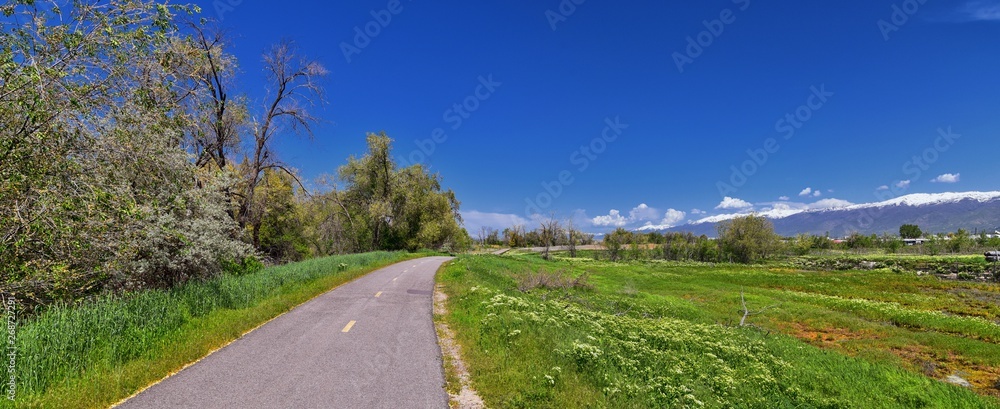 Φωτογραφία Jordan River Parkway Trail, Redwood Trailhead bordering the Legacy Parkway Trail, panorama views with surrounding trees and silt filled muddy water along the Rocky Mountains, Salt Lake City, Utah