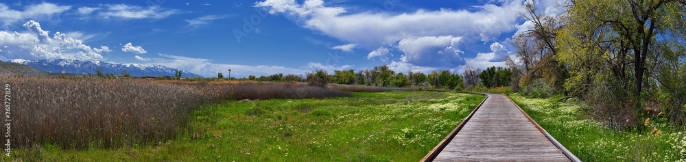 Jordan River Parkway Trail, Redwood Trailhead bordering the Legacy Parkway Trail, panorama views with surrounding trees and silt filled muddy water along the Rocky Mountains, Salt Lake City, Utah. Jordan River Parkway Trail, Redwood Trailhead bordering the Legacy Parkway Trail, panorama views with surrounding trees and silt filled muddy water along the Rocky Mountains, Salt Lake City, Utah.