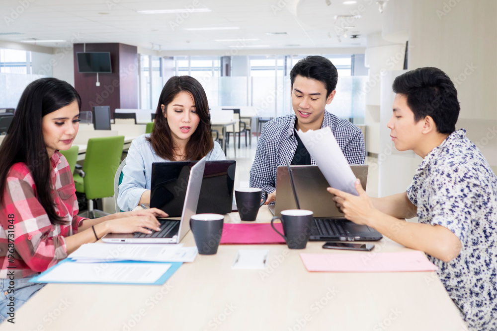 Busy business team works with laptops in office Busy business team works with laptops in office